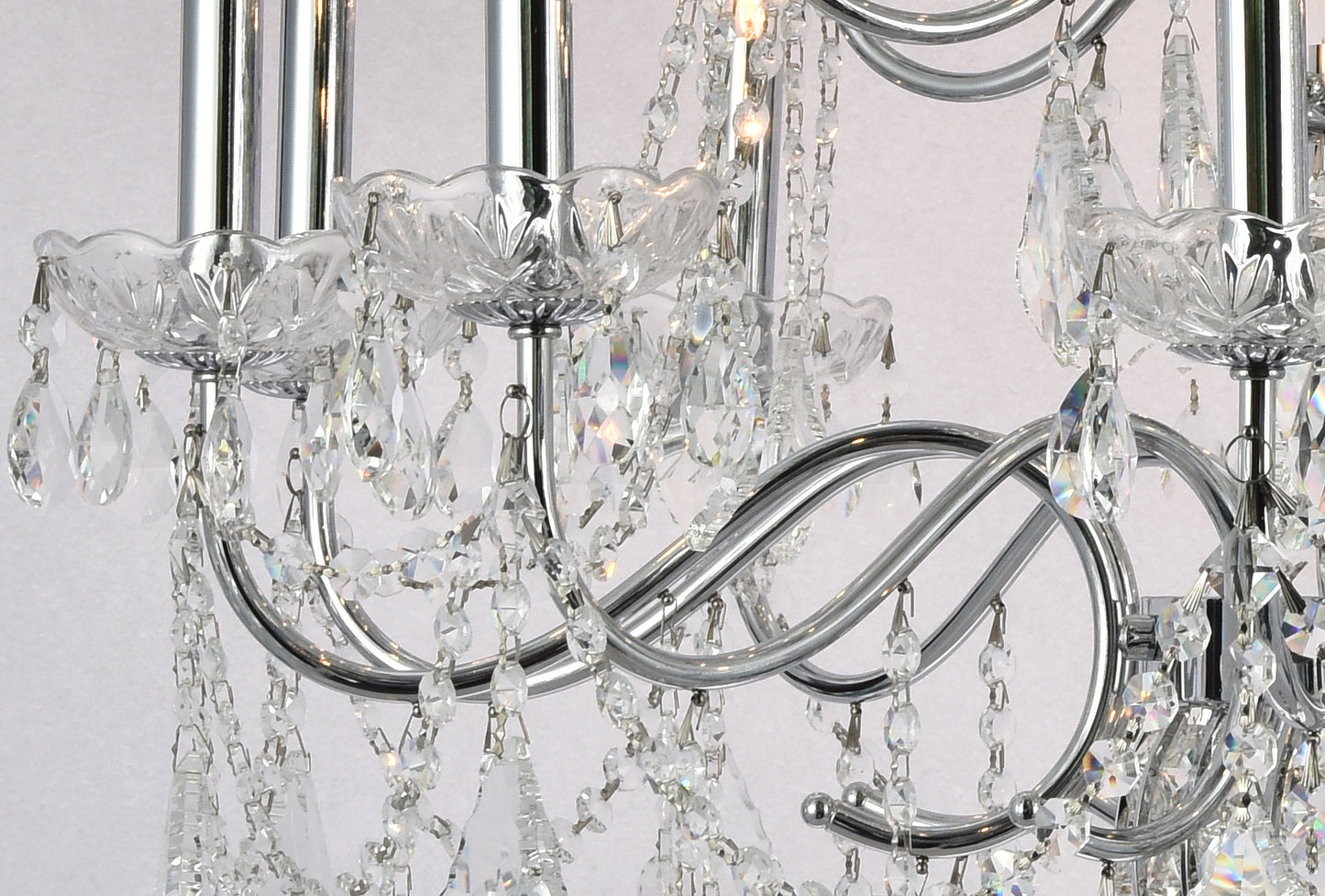 Close-up of the polished chrome arms and glass bobeches draped with delicate crystal bead garlands.