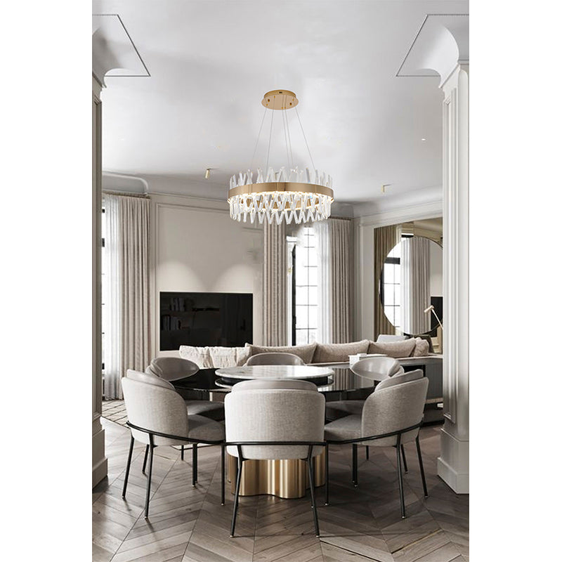 Gold and crystal round chandelier installed in a bright modern dining area, emphasizing its clean, architectural lines.