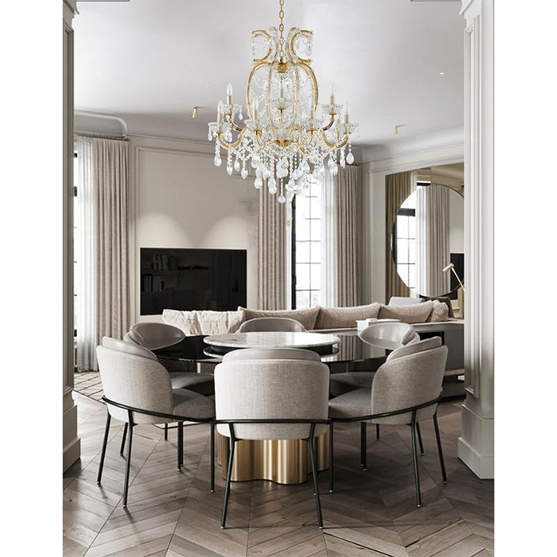 Large 39-inch satin brass 2-tier crystal chandelier suspended in a luxury dining room over a round black table.