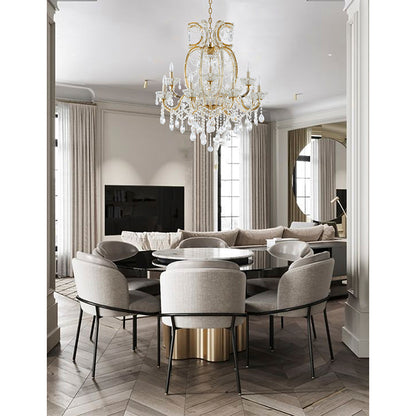 Large 39-inch satin brass 2-tier crystal chandelier suspended in a luxury dining room over a round black table.