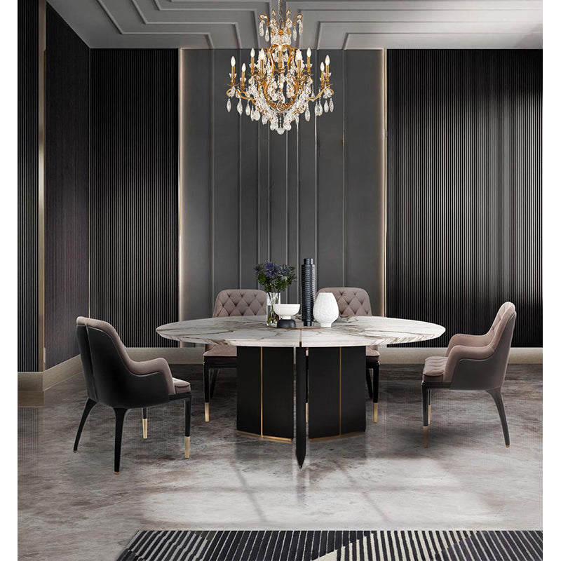 Three-tiered antique brass crystal chandelier hanging in a luxury dining room with a marble table and velvet chairs.