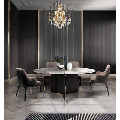 Three-tiered antique brass crystal chandelier hanging in a luxury dining room with a marble table and velvet chairs.