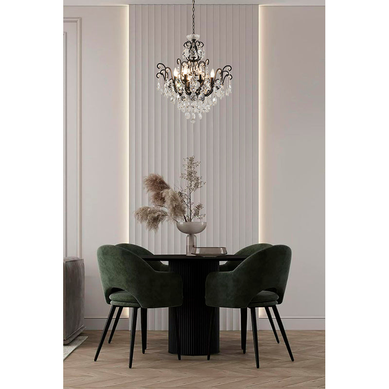 Compact matte black chandelier with clear crystals suspended over a small round dining table in a cozy apartment nook.