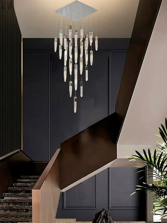 The ADS17C41CH 41-light chrome chandelier suspended over a modern grand staircase with dark wood paneling and a large indoor plant.