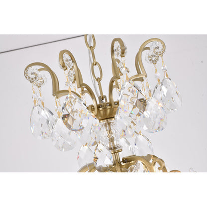 Close-up of the upper tier of the brass chandelier featuring scrollwork arms and hanging crystal prisms.