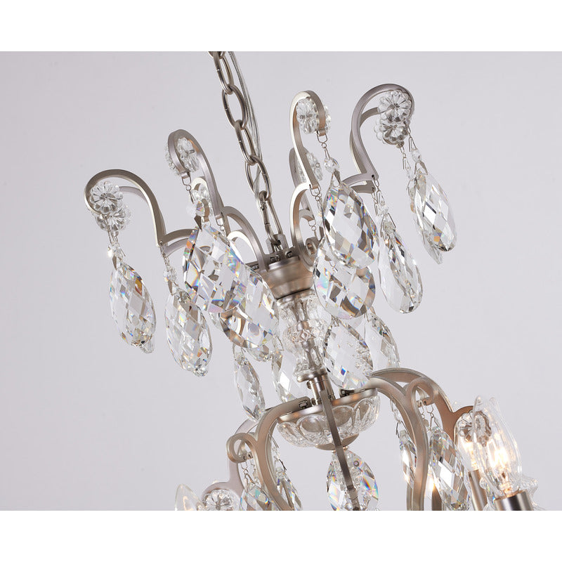 Close-up of the upper pewter scroll arms and hanging faceted crystal prisms against a light background.