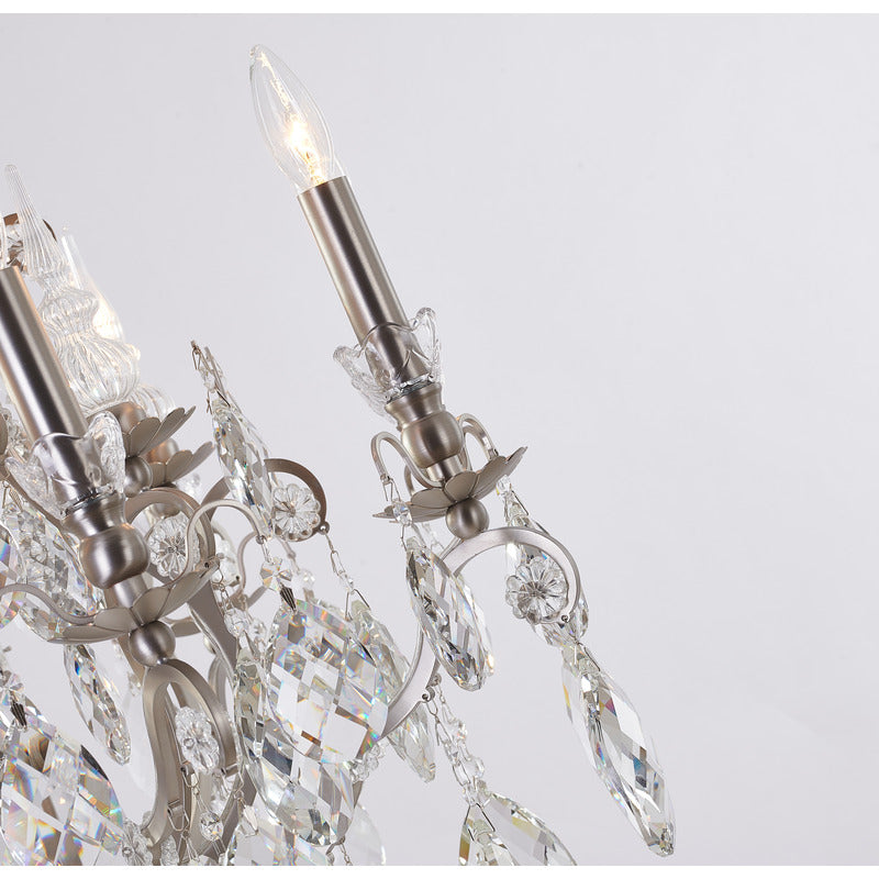 Macro shot of a pewter scroll arm draped with multi-layered crystal strands and teardrop pendeloques.