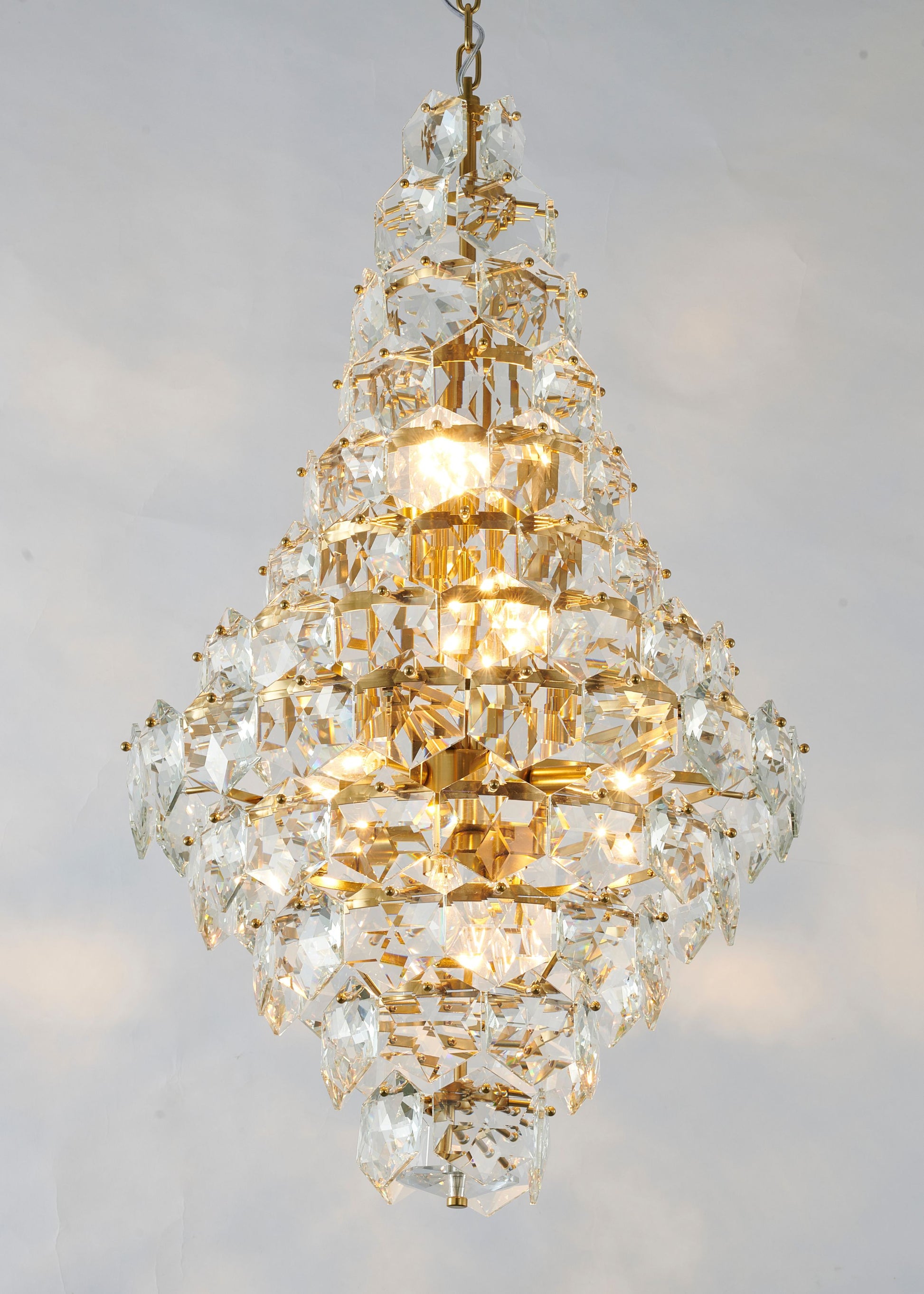 Brass Tear Drop 36-inch crystal chandelier for dining rooms, shown lit.